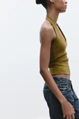 Top color crema con cuello halter y escote redondo. Espalda descubierta.