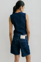 Bermuda de denim con estampado abstracto en tonos naranja, celeste y negro.