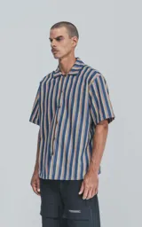 Camisa de manga corta con cuello cubano y estampado a rayas verticales en tonos azul, amarillo y rojo.