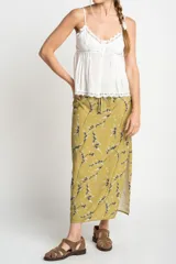Blusa blanca de algodón con tirantes finos y escote en V. Presenta detalles de encaje en el escote y en el ruedo, y cierre frontal con botones.