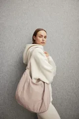 Bolso de deporte color rosa con correa ancha ajustable y cierre.