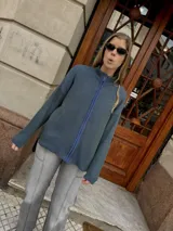 Campera tejida color azul con textura vanizada y cierre frontal.