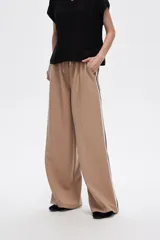 Pantalón negro ancho de viscosa con vivos laterales en blanco, dorado y marrón.