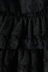 Minifalda negra con bordado floral y volantes escalonados.