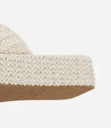 Sandalia flatform con superficie trenzada metalizada color dorado, sin cierre, con tira ancha y puntera redonda.