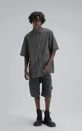 Camisa de manga corta, corte oversize, color negro con efecto desgaste. Confeccionada en algodón bordado (broderie) con diseño floral y calado.