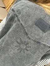 Chaleco de jean gris con bordados de caballos y estrellas en hombros y espalda.