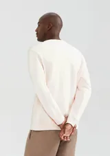 Buzo color beige de corte clásico con estampa rectangular con imagen y texto en el pecho.