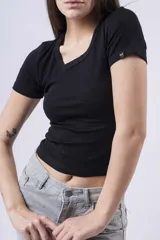 Remera blanca de manga corta, corte ajustado y escote redondo. Presenta un pequeño detalle de etiqueta negra en la manga izquierda.