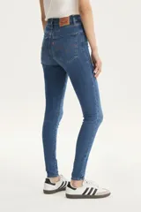 Jeans de tiro alto color azul, ajustados en cadera y muslos, con pierna súper ajustada y denim stretch.
