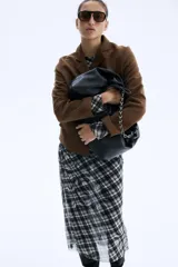 Chaqueta corta marrón de tejido suave con acabado cepillado, solapas de muesca, cierre frontal de dos botones y dos bolsillos delanteros con solapa.