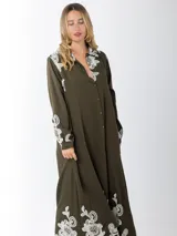Maxi vestido camisero verde militar confeccionado en lino bordado, de calce amplio y estilo oversized.