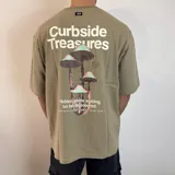 Remera color caqui de corte oversize con estampado de hongos y texto en la espalda.