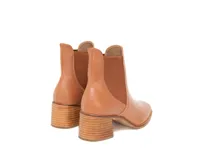 Botines de cuero en tono caramelo, con diseño limpio, paneles laterales elásticos y tacón de bloque en madera clara.