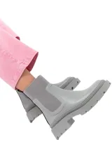 Botines grises ceniza de cuero liso con detalles texturizados, inserciones elásticas laterales, tirador trasero y suela track robusta.