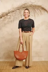 Pantalón ancho color beige de lino con cinto y pretina con elástico en la parte de atrás.