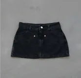 Mini falda de jean color negro con tiro bajo.