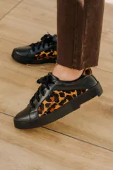 Zapatillas deportivas acordonadas de cuero vacuno negro con estampado animal print de leopardo en los laterales.