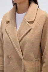 Tapado de poliéster color gris con cuello de solapa y cierre frontal de botones. Cuenta con mangas largas y un diseño de corte recto.