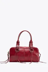 Bolso bowling color rojo con efecto craquelado. Tiene doble asa de hombro con detalles metálicos y asa bandolera extraíble. Incluye bolsillo interior con cremallera y cierre principal con cremallera.