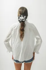 Camisa blanca de lino de manga larga con cuello clásico y cierre frontal con botones.