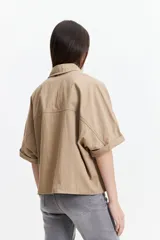 Camisa color beige de corte oversize y manga corta.