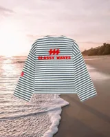 Buzo de manga larga con cuello redondo y corte holgado. Presenta un diseño a rayas horizontales en azul y blanco, con estampa roja en el frente que incluye texto y símbolos.