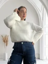 Sweater de punto color blanco con cuello redondo y mangas largas abullonadas.