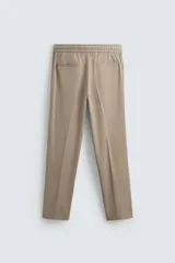Pantalón color topo de corte recto, con cintura elástica ajustable con cordón, bolsillos laterales y bolsillos de vivo en la espalda.