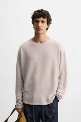 Jersey color beige de punto tejido en hilatura ligera de lino, con cuello redondo, manga larga y acabados en rib.