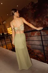 Pollera larga color verde oliva, con base fruncida, transparencias y pequeños volados verticales.