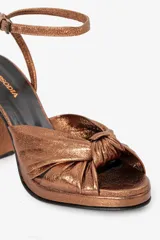 Sandalias negras de cuero metalizado con taco alto y tira fina al tobillo.