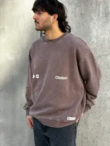 Buzo marrón con estampado en la espalda que incluye un sol, la palabra "Osten" y las frases "Empower Elevate Your" y "Boldness Strenght".