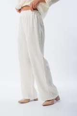Pantalón palazo blanco con estampado animal print, cintura elastizada y lazo ajustable.