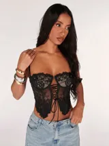 Corset negro de encaje con copas con aros y cordones ajustables en el frente.