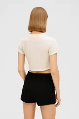 Remera cropped color rosa con estampado de conchas marinas en color rojo, corte holgado y cuello redondo.