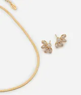Conjunto de collar y aros dorados con forma de flor y detalle de zirconia.