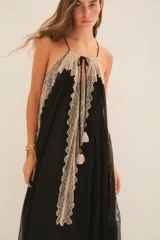 Vestido largo negro con breteles finos, escote en V y detalles de encaje color beige en el escote, laterales y ruedo.