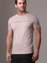 Remera color gris topo de manga corta y cuello redondo, con logo "Calvin Klein Jeans" estampado en plateado en el pecho.