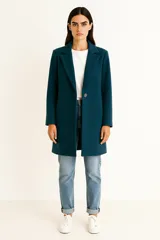 Tapado de poliéster color verde azulado, de manga larga, con solapa y un botón frontal.