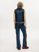 Pantalón de jean gris oscuro con corte oxford y apliques metálicos alrededor de los bolsillos y en la parte externa.