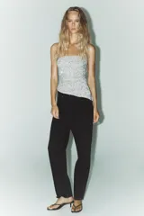 Pantalón de jean celeste, de tiro alto, corte mom fit, con cinco bolsillos y cierre frontal con cremallera y botón metálico.