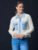Campera combinada de punto color crema con detalles en denim celeste. Tiene cuello con solapa, cierre frontal con botones metálicos, bolsillos delanteros y corte recto.