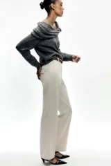 Pantalón negro de tiro alto con pernera recta, bolsillos frontales y falsos bolsillos con solapa en la espalda. Incluye cinturón marrón de cuero sintético.
