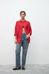 Camisa roja de lino, de corte holgado, con cuello clásico, mangas 3/4 y cierre frontal con botones.