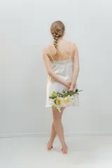 Camisón corto color blanco de satén elastizado con breteles finos y escote en V con detalle de puntilla elastizada en el escote y al centro de la delantera en el largo, espalda recta con puntilla.