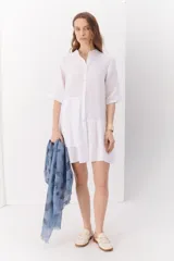 Vestido blanco de lino con cuello mao, manga corta y corte evasé.