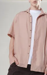 Camisa color beige de manga corta con calce oversize y canesú en la espalda.
