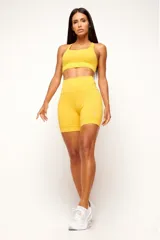 Conjunto deportivo negro compuesto por un top con diseño nadador, bolsillo trasero y detalles reflectivos, y un biker con cinturón 360° con bolsillo interno, bolsillos laterales y detalles reflectivos.