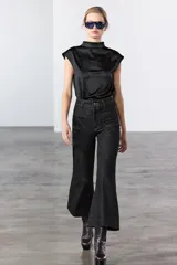 Pantalón de jean celeste de tiro alto y corte wide leg, con bolsillos frontales y traseros, cierre frontal con cremallera y botón metálico.